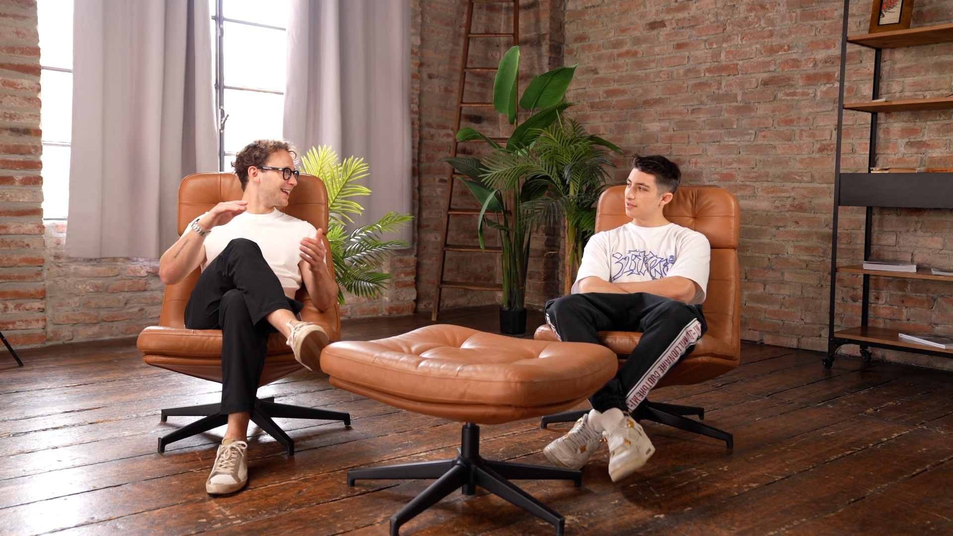 Set podcast industriale con divano chesterfield e grandi vetrate, Diverso Podcast Studio Milano